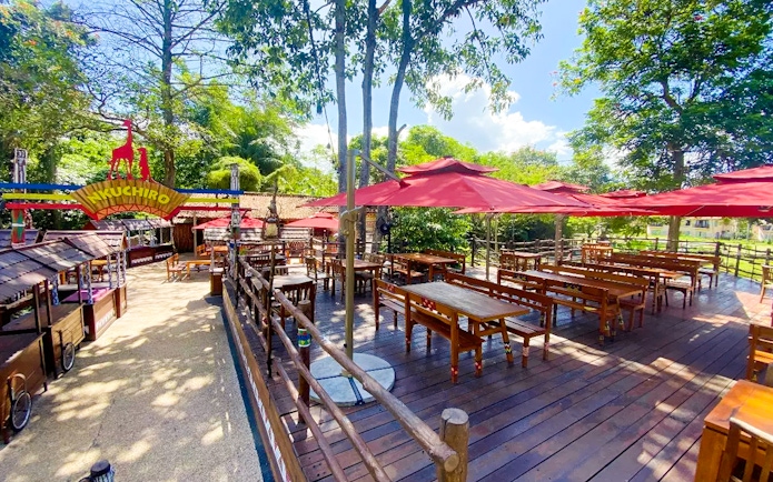 Outdoor dining area with red umbrellas at Bali Safari and Marine Park.
