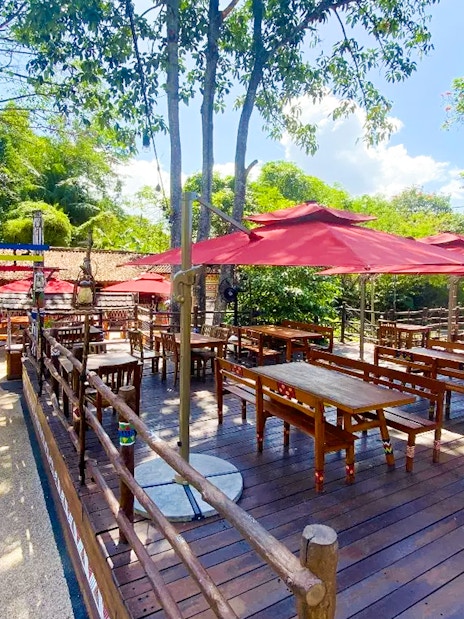 Outdoor dining area with red umbrellas at Bali Safari and Marine Park.