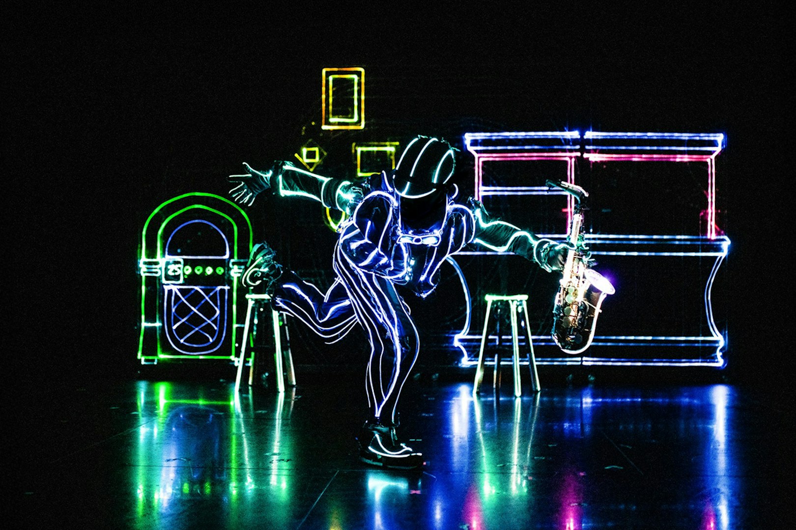 Performer in LED suit playing saxophone at iLuminate show.