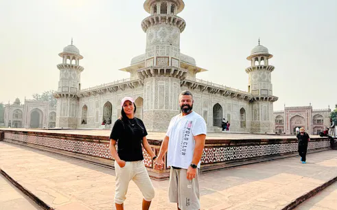 Visitors at the Baby Taj, Agra, with intricate marble architecture in the background.