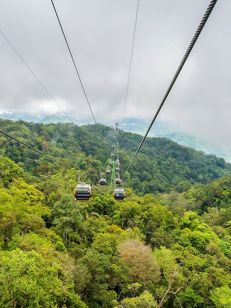Cable car over lush forest at Sun World Ba Na Hills, Vietnam.
