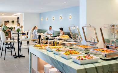 Buffet and seating area at Plaza Premium Lounge with guests dining.