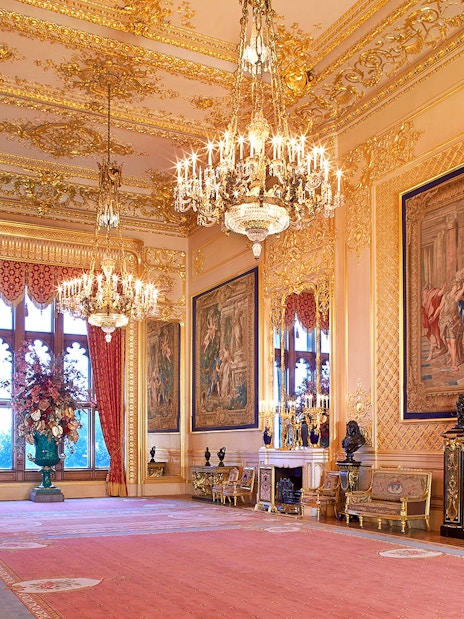 Windsor Castle's opulent room with chandeliers, ornate tapestries, and gilded decor.