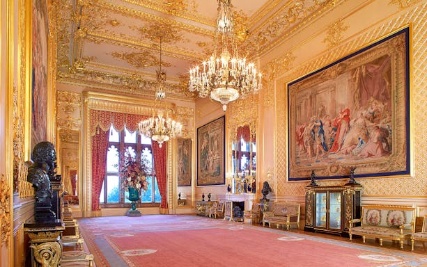 Windsor Castle's opulent room with chandeliers, ornate tapestries, and gilded decor.