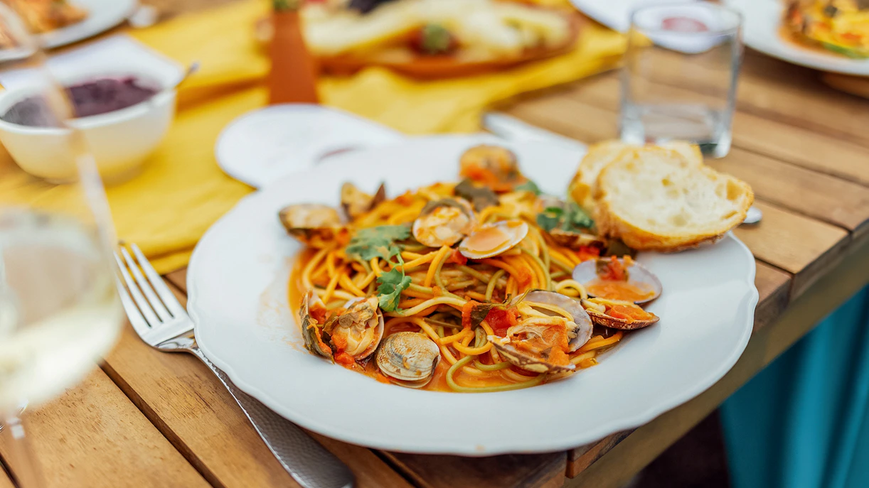 Seafood pasta dish served on a wooden table in Cinque Terre, Italy.