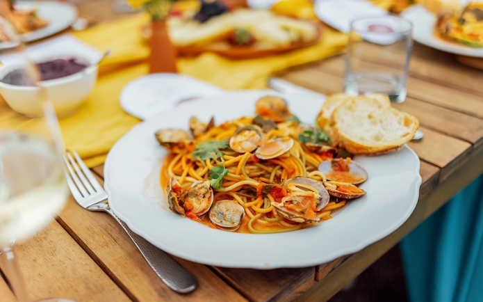 Seafood pasta dish served on a wooden table in Cinque Terre, Italy.