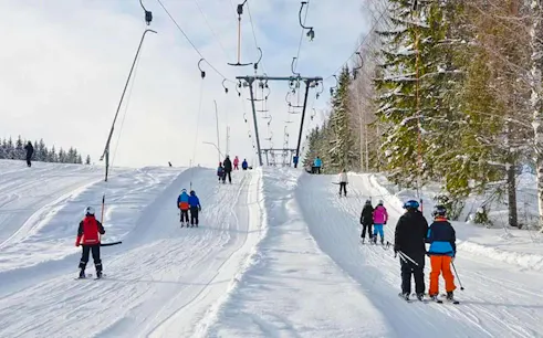 Skiers on a snowy slope using a cable car lift in Bursa, Turkey.
