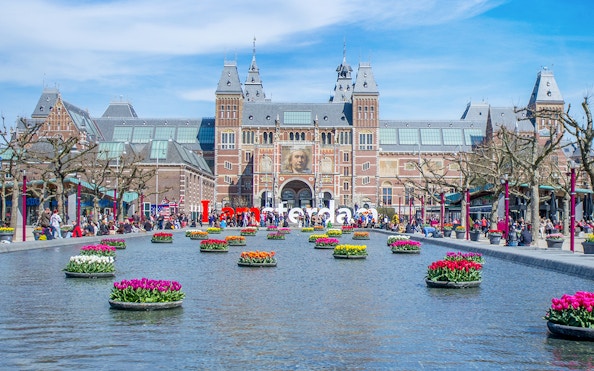 Rijksmuseum Amsterdam with tulip garden and reflecting pool.