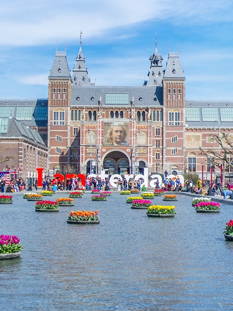 Rijksmuseum Amsterdam with tulip garden and reflecting pool.