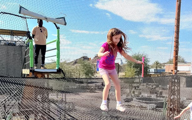 Child enjoying trampoline at Hatta Wadi Hub adventure park.