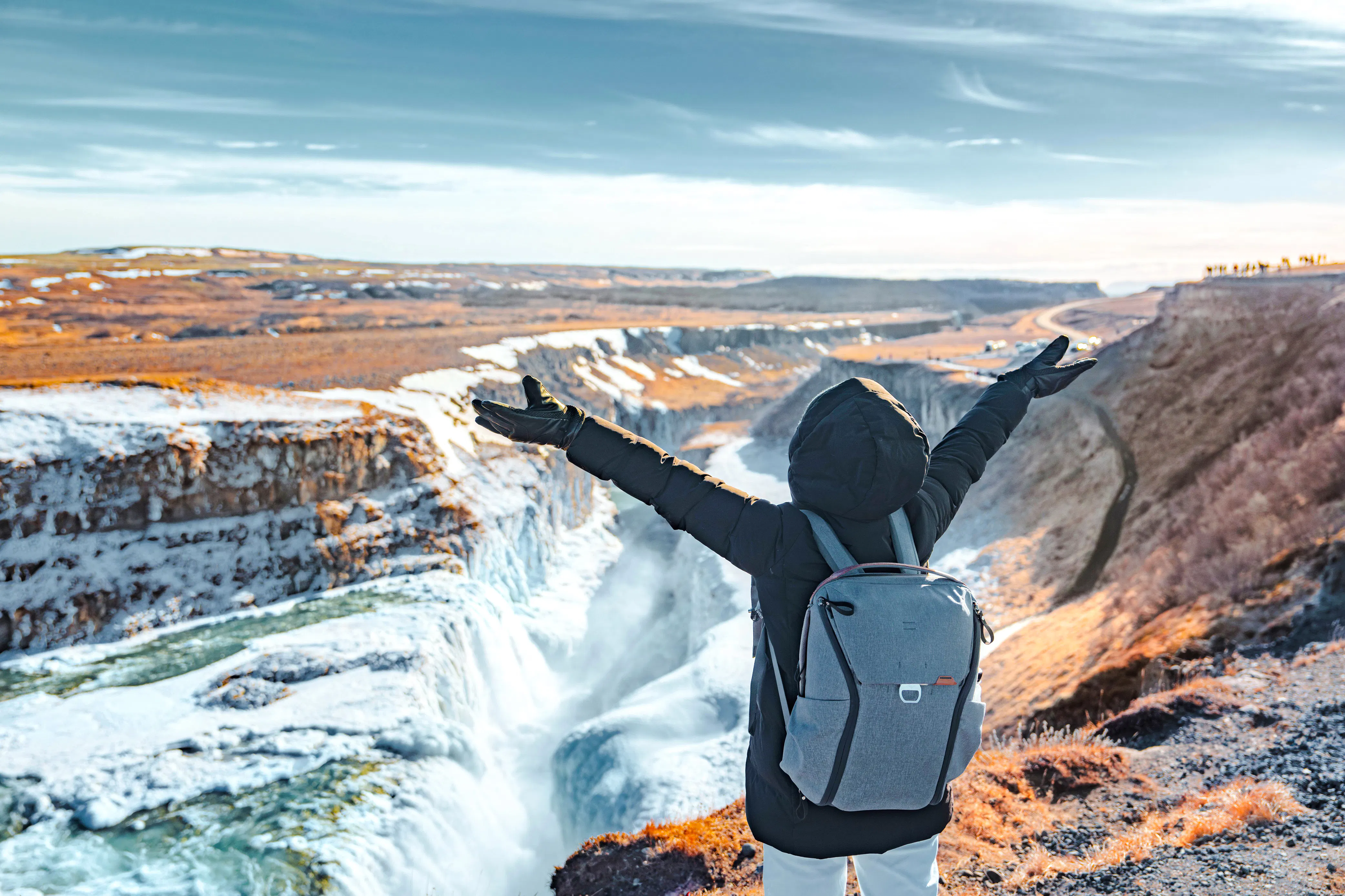 Person with arms raised overlooking Gullfoss waterfall on Golden Circle tour, Reykjavik.