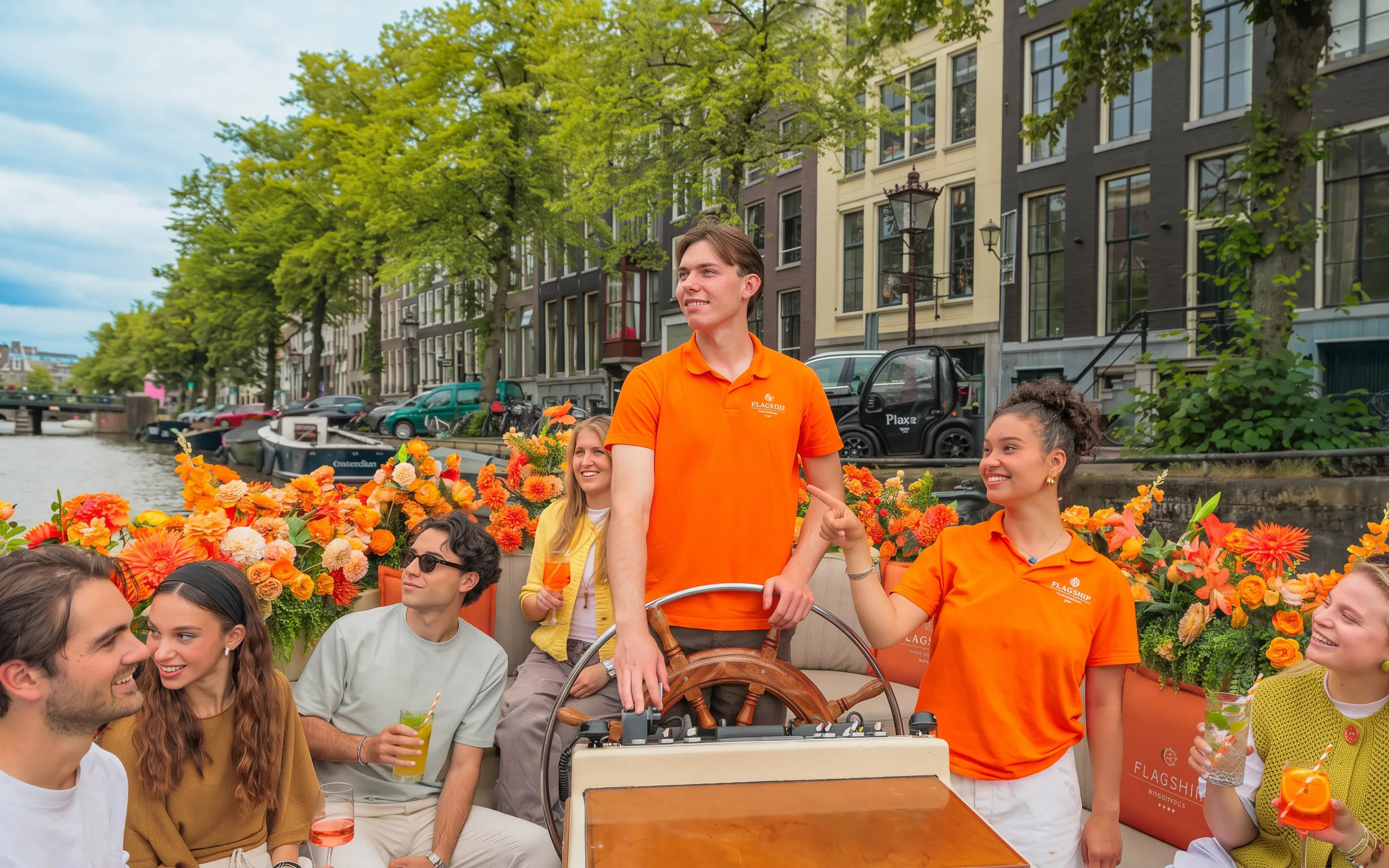 Guests enjoying a canal cruise in Amsterdam with vibrant flowers and historic buildings in the background.