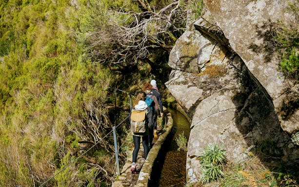 Hikers walking along the Rabaçal 25 Fountains levada trail in Madeira.