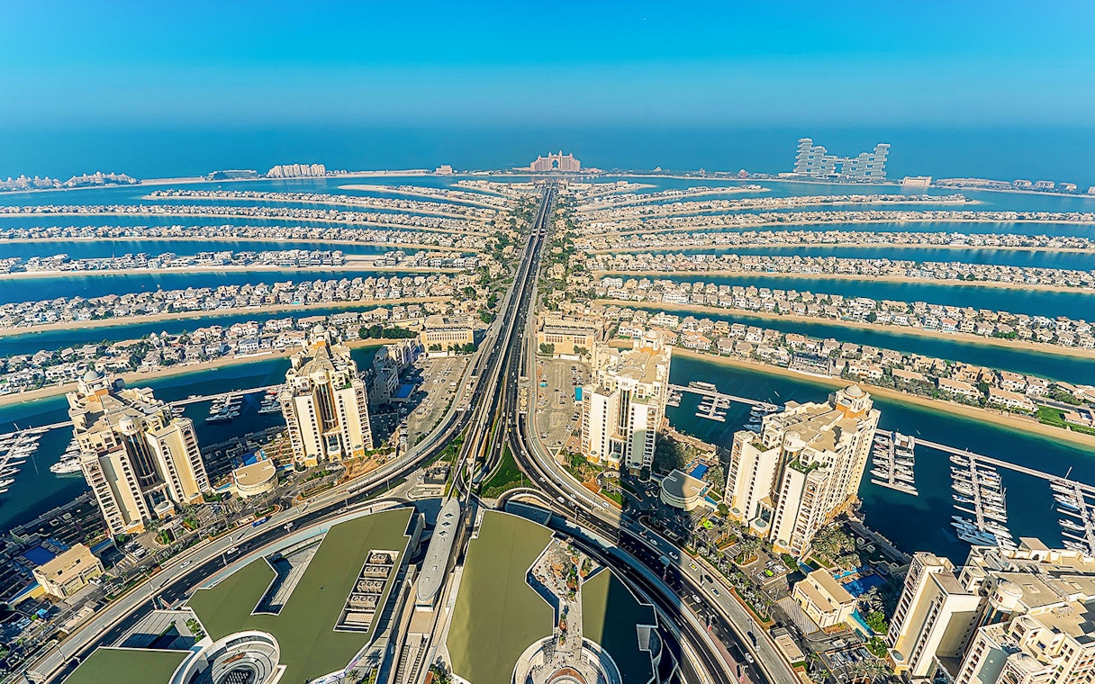 Aerial view of Palm Jumeirah in Dubai at sunrise, showcasing the iconic palm-shaped islands.