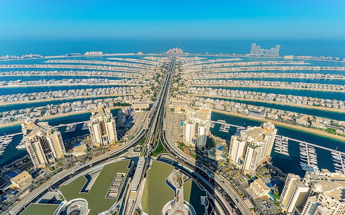 Aerial view of Palm Jumeirah in Dubai at sunrise, showcasing the iconic palm-shaped islands.