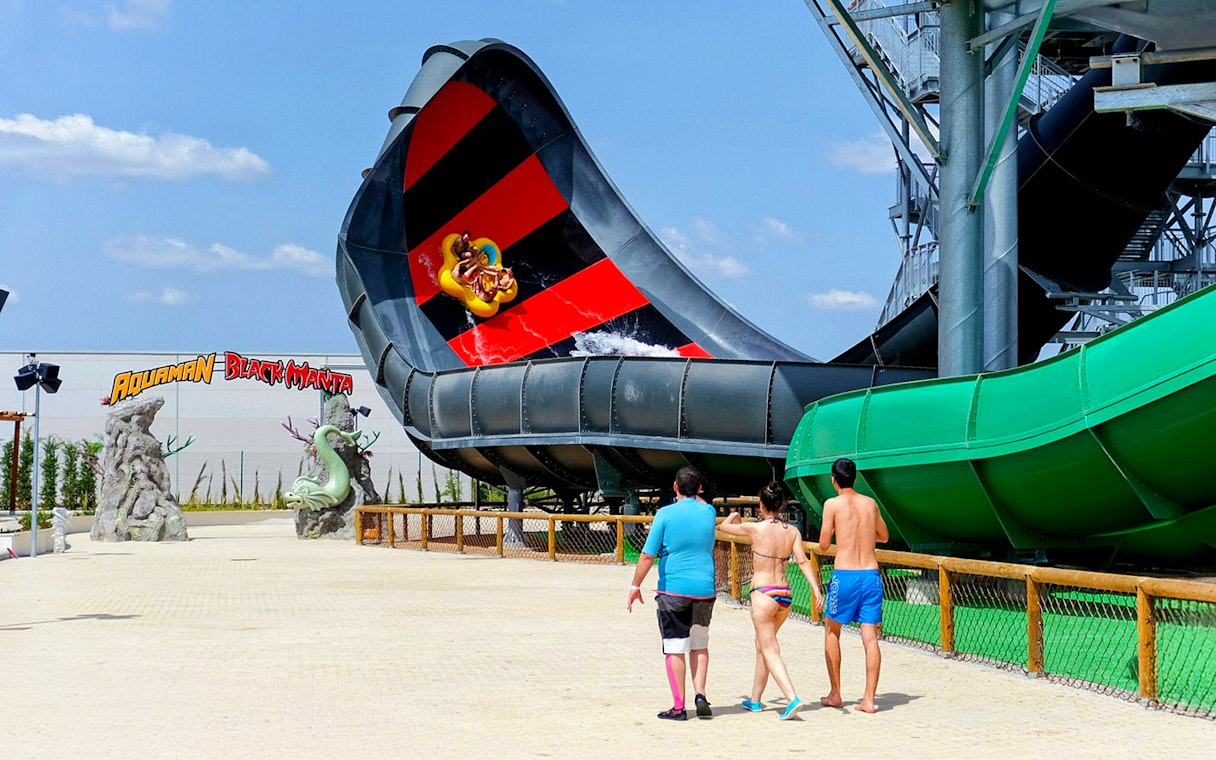 Visitors approach Aquaman Black Manta water slide at Parque Warner, Madrid.