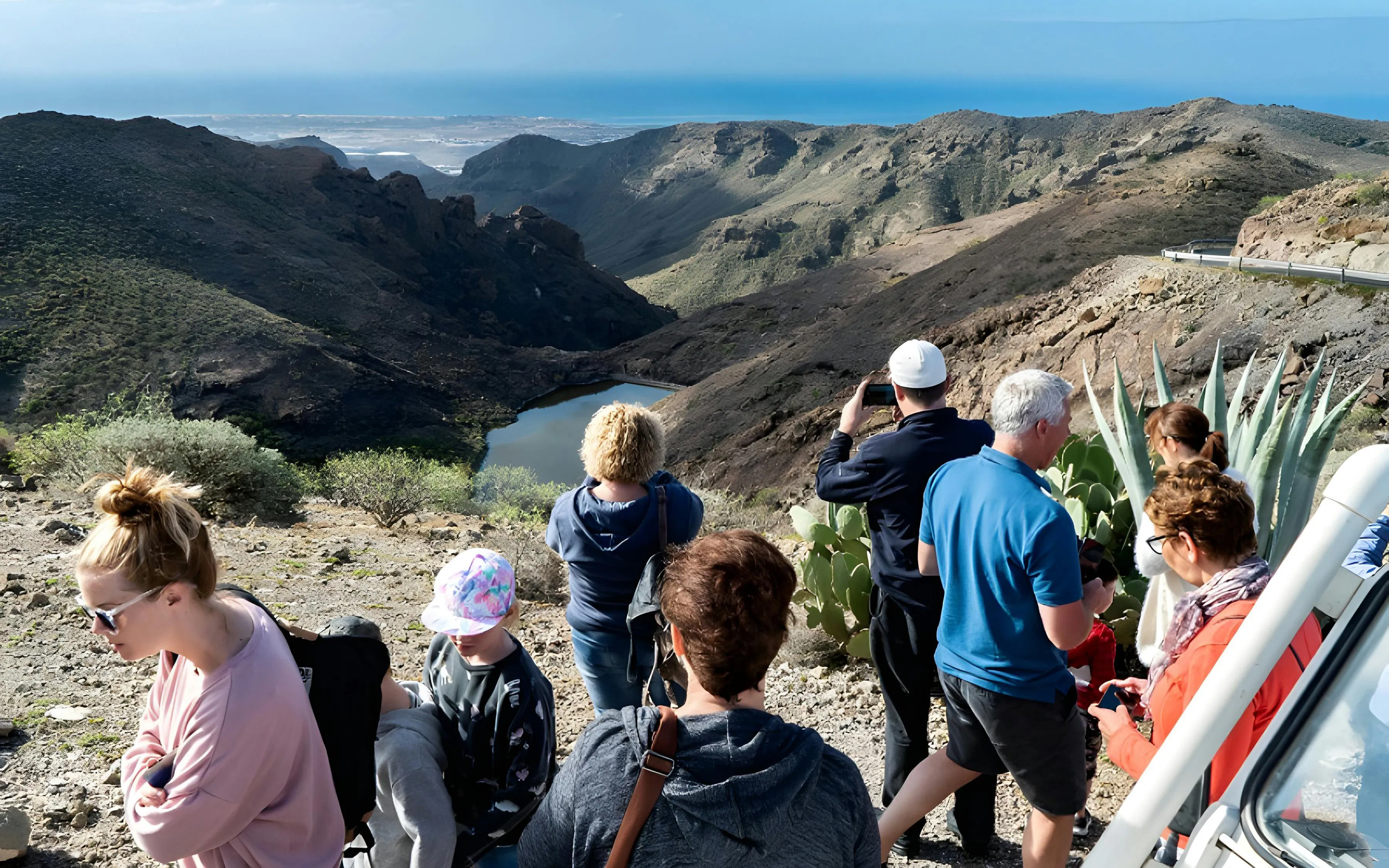 Tourists enjoying a scenic view of Gran Canaria's rugged landscape during a jeep safari.