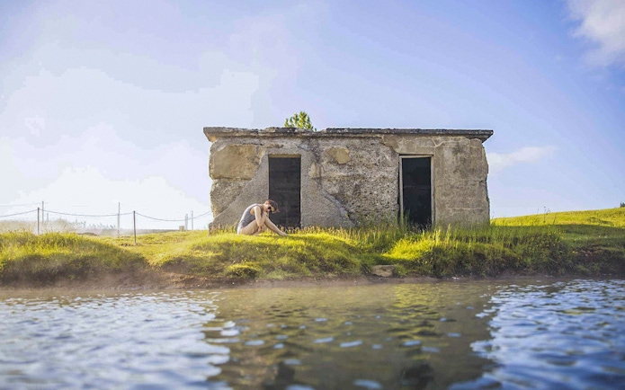 Guests relaxing by the water at Secret Lagoon Gamla Laugin, Iceland.