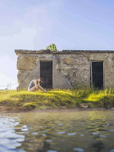 Guests relaxing by the water at Secret Lagoon Gamla Laugin, Iceland.