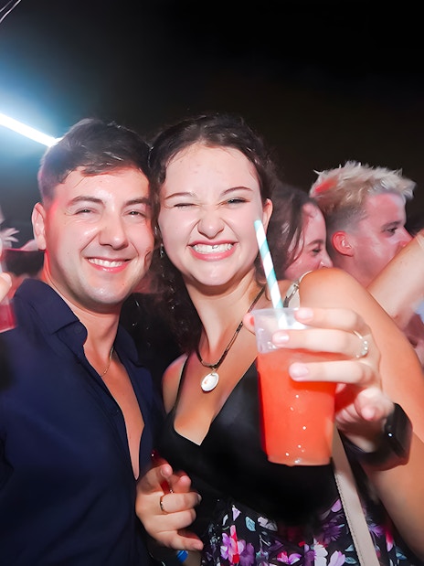 Group enjoying drinks on a lively boat crawl at night.
