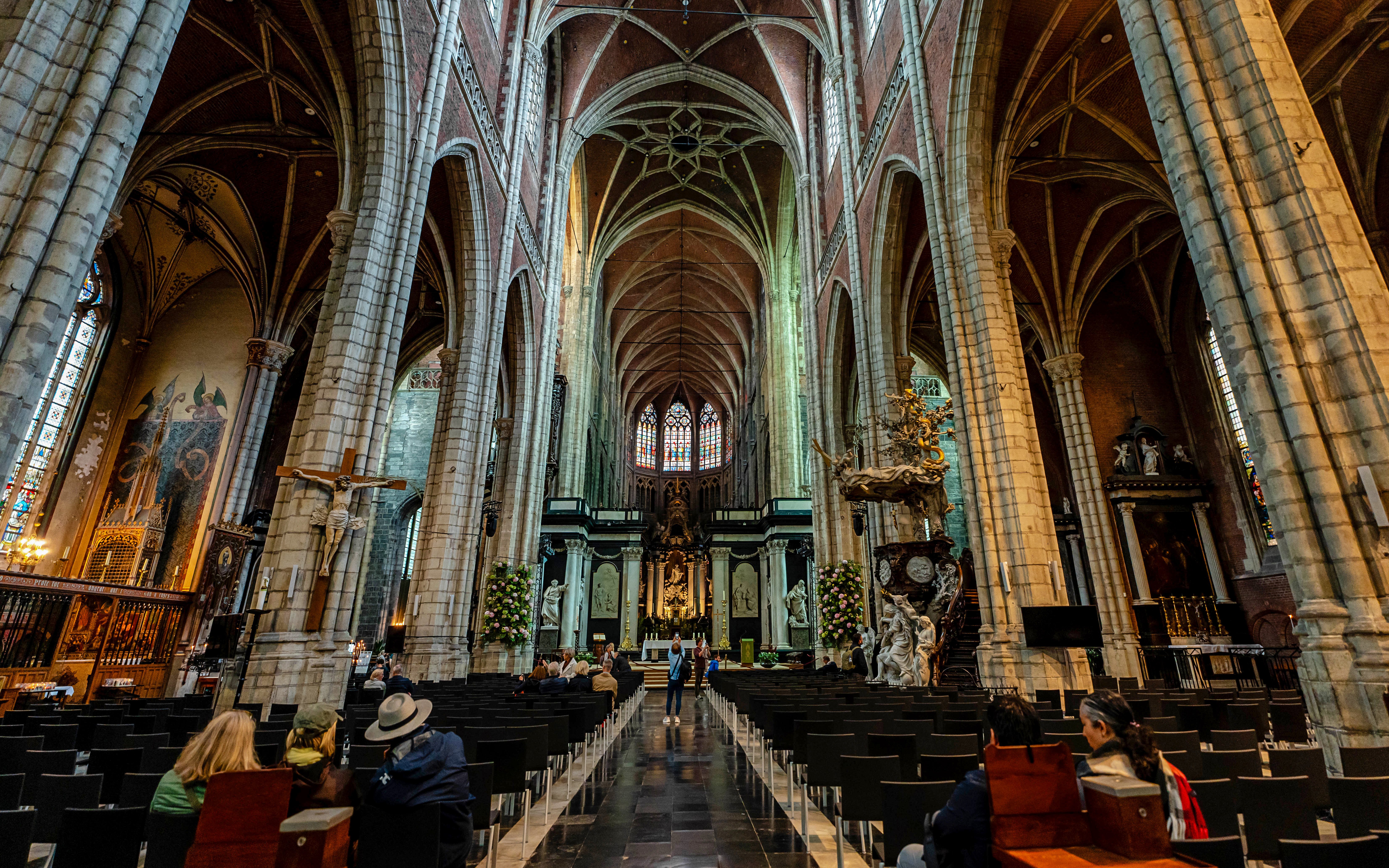 Interior view of Saint Bavo's Cathedral in Ghent, Belgium, showcasing its vaulted ceilings and ornate altar.
