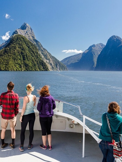 Tourists on a boat cruise in Milford Sound, New Zealand, viewing scenic fjords.