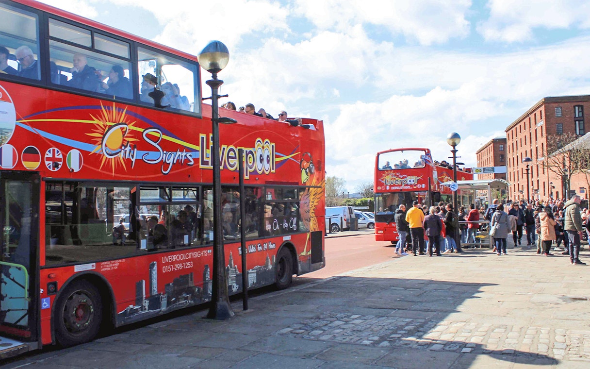 Hop On Hop Off bus in Liverpool waiting for passengers at a city tour stop.