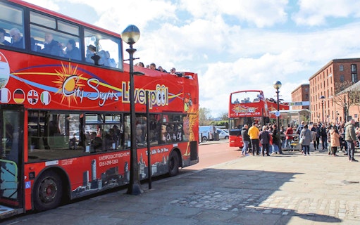 Hop On Hop Off bus in Liverpool waiting for passengers at a city tour stop.
