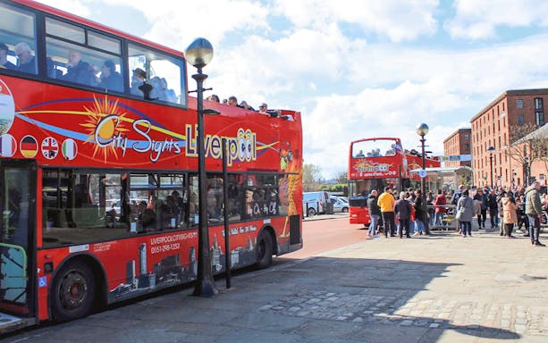 Hop On Hop Off bus in Liverpool waiting for passengers at a city tour stop.