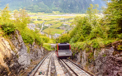 Funicular ascending Harder Kulm with scenic view of Interlaken and surrounding mountains.