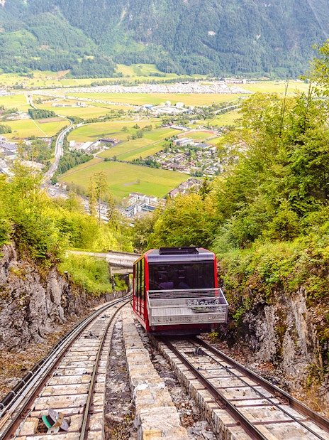 Funicular ascending Harder Kulm with scenic view of Interlaken and surrounding mountains.