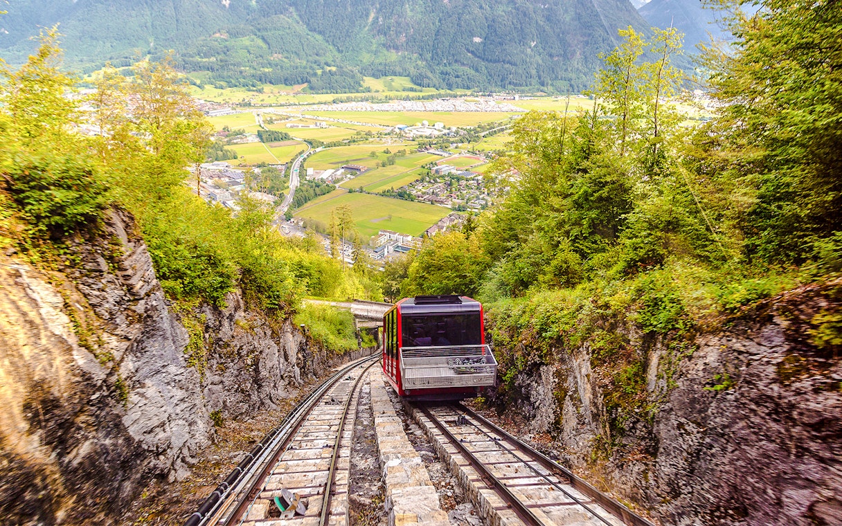 Funicular ascending Harder Kulm with scenic view of Interlaken and surrounding mountains.