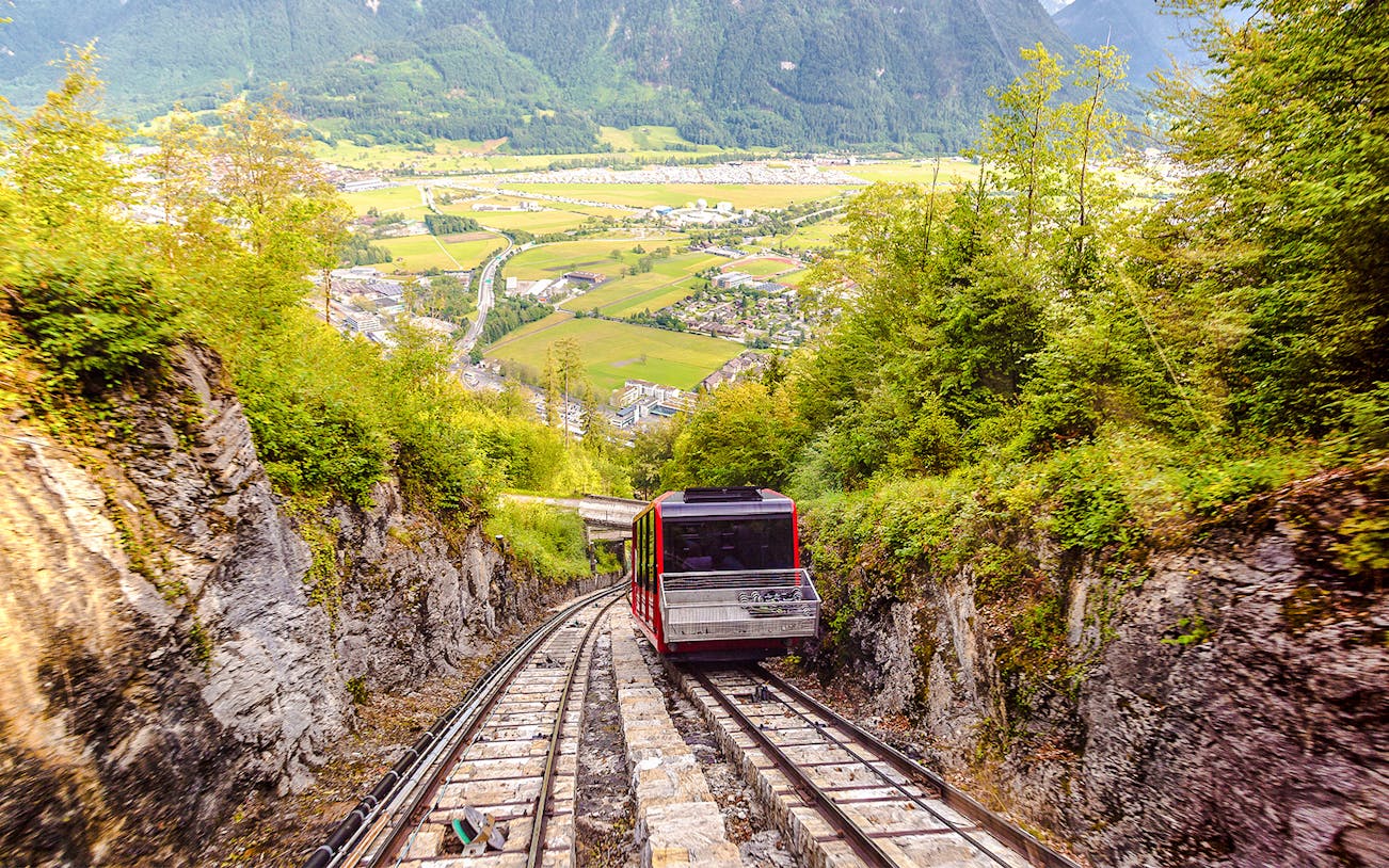 Funicular ascending Harder Kulm with scenic view of Interlaken and surrounding mountains.