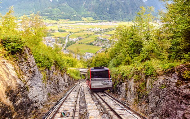 Funicular ascending Harder Kulm with scenic view of Interlaken and surrounding mountains.