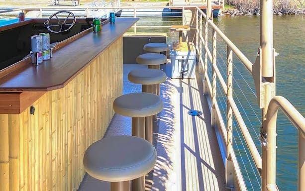 Tiki bar stools on a Prague floating boat tour with river view.
