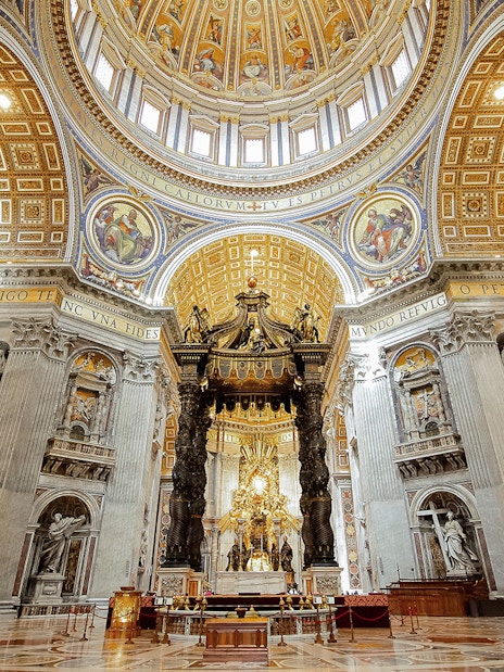 St. Peter’s Basilica interior with ornate dome and Bernini's Baldachin, Vatican City.