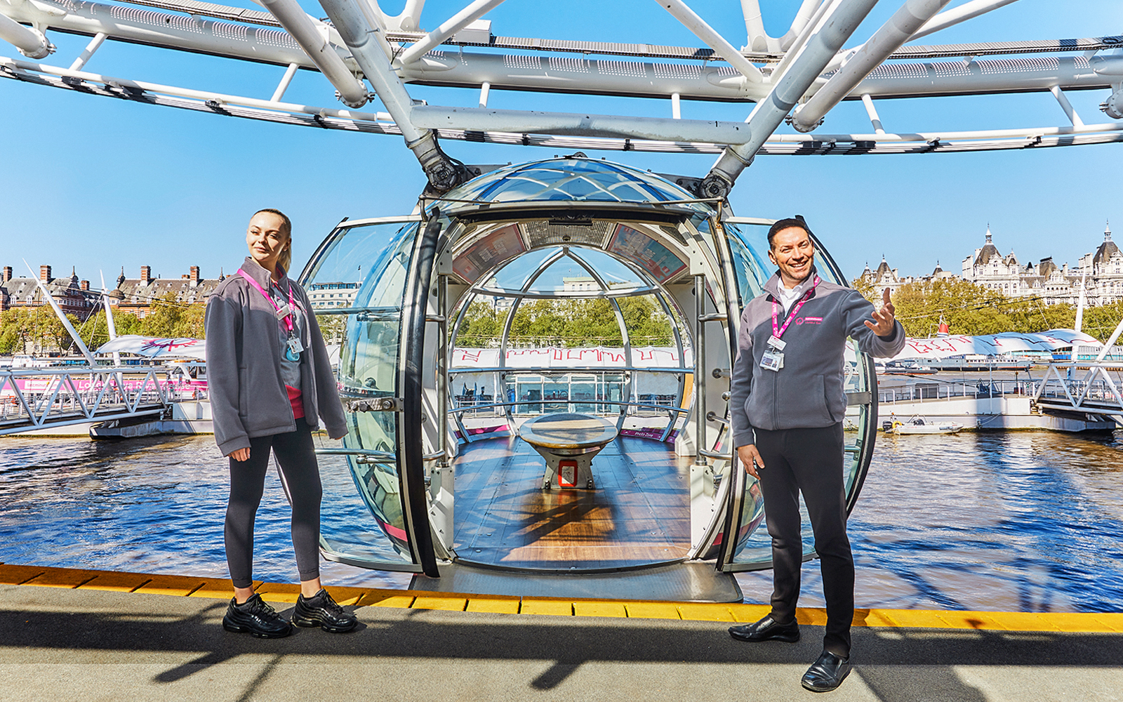 London Eye capsule with two guides welcoming visitors.