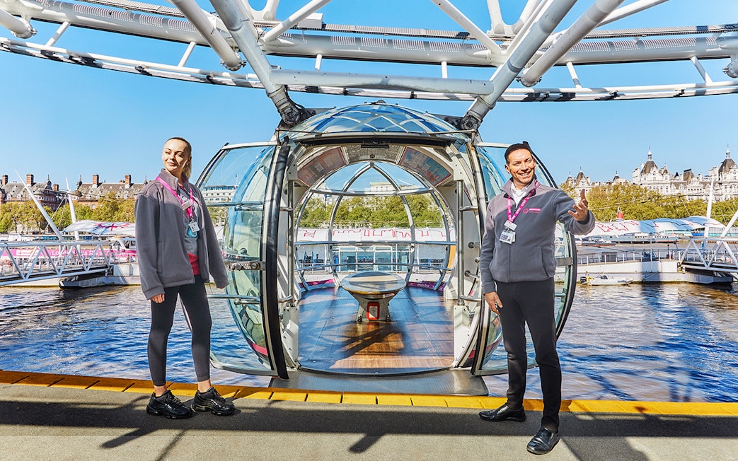 London Eye capsule with two guides welcoming visitors.
