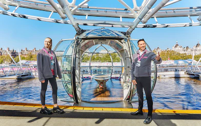 London Eye capsule with two guides welcoming visitors.