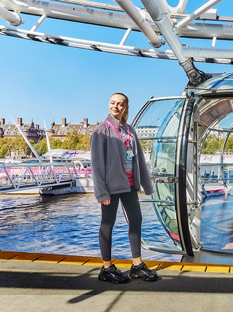 London Eye capsule with two guides welcoming visitors.