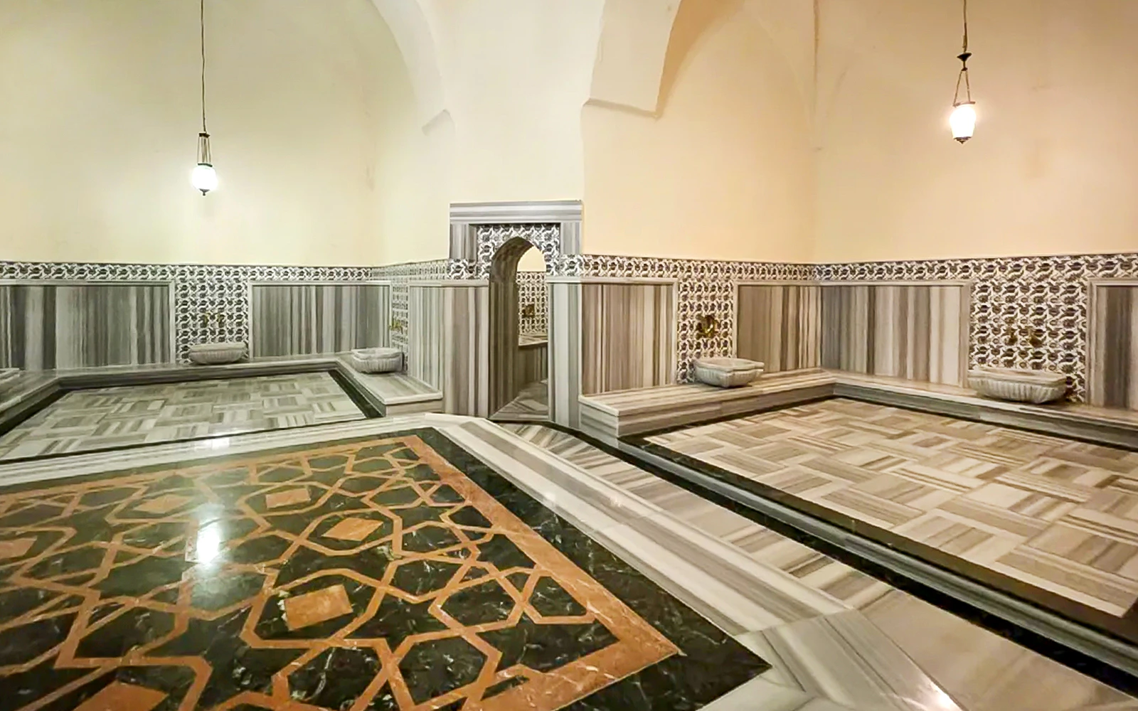 Interior of Gedikpasa Hammam with marble floors and ornate wall tiles.