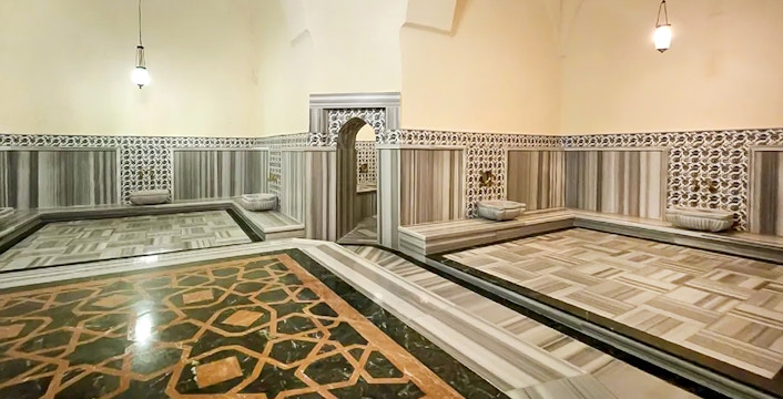 Interior of Gedikpasa Hammam with marble floors and ornate wall tiles.
