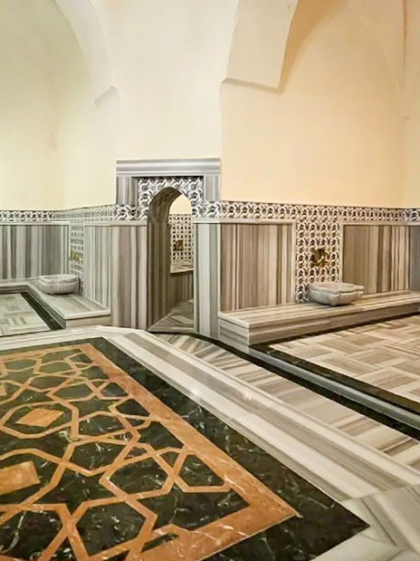 Interior of Gedikpasa Hammam with marble floors and ornate wall tiles.