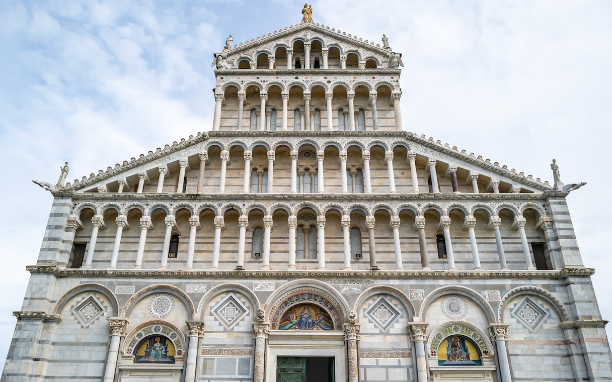 Facade of Pisa Cathedral with ornate arches and sculptures.