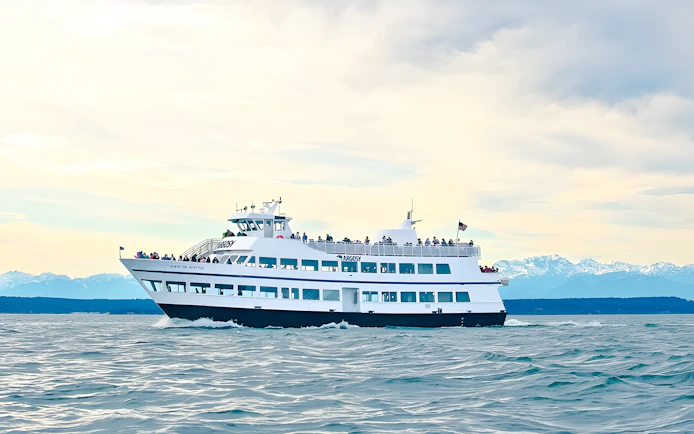 Argosy Cruises vessel on Seattle Locks cruise with mountains in the background.