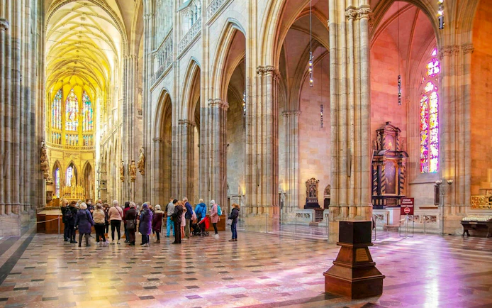 Visitors touring the interior of St. Vitus Cathedral at Prague Castle.
