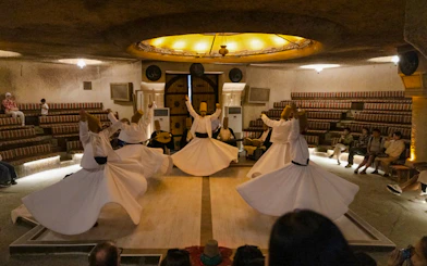 Whirling Dervishes performing Sema ceremony in a cave setting, Cappadocia.