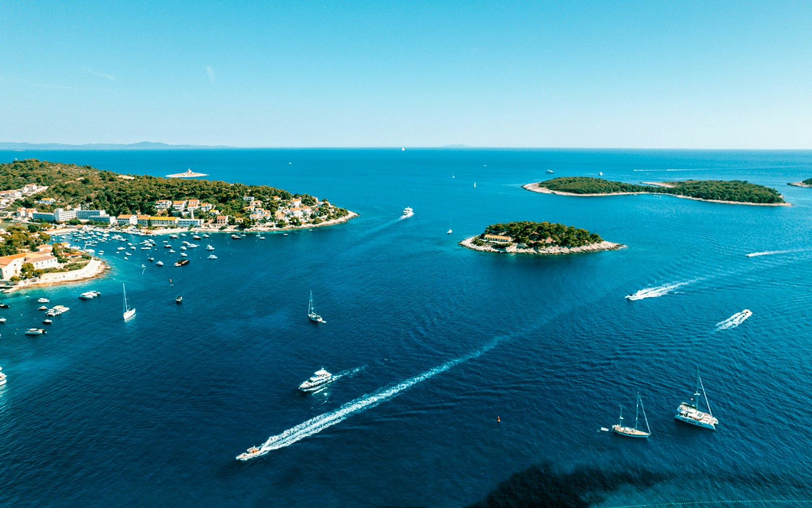 Aerial view of Pakleni Islands, Croatia, with boats navigating the clear blue waters.