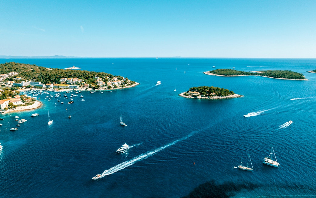 Aerial view of Pakleni Islands, Croatia, with boats navigating the clear blue waters.
