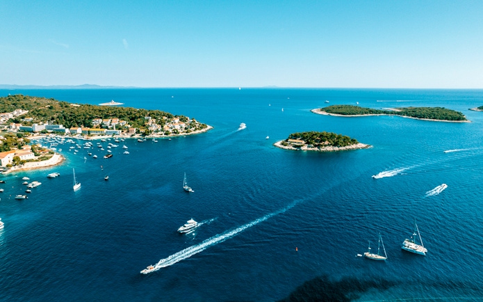 Aerial view of Pakleni Islands, Croatia, with boats navigating the clear blue waters.